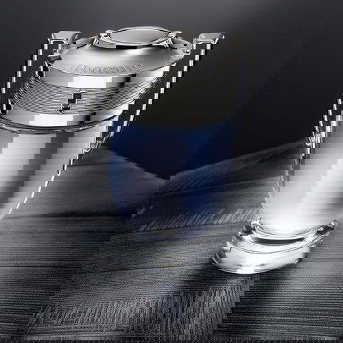 Снимок флакона Paco Rabanne Invictus в форме трофея на тёмном фоне — минималистичная рекламная фотография мужского аромата.