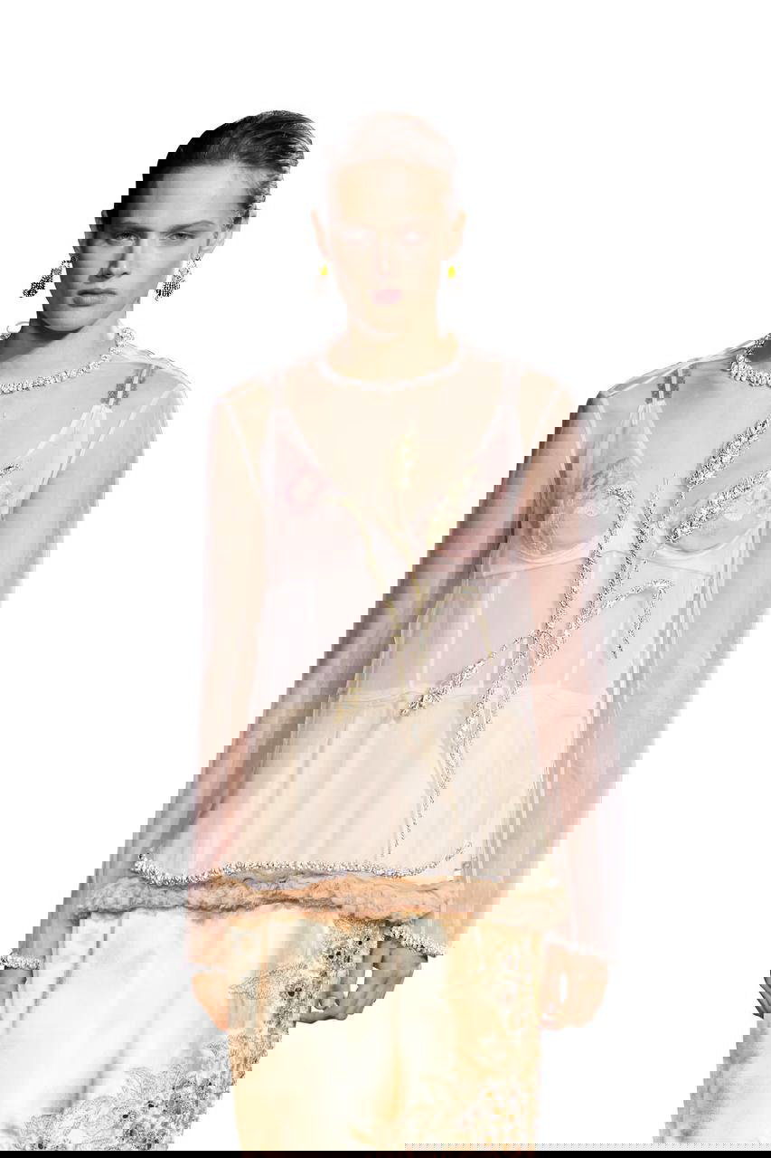 Модель в полупрозрачной блузе и нежном бра с акцентом на колье и серьги — образ подиумной съёмки, подчёркивающий жемчуг и пастель