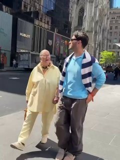 Симон Порта идёт по улице, держa руку бабушки в светлом костюме — прогулка пары в преддверии выхода на Met Gala.
