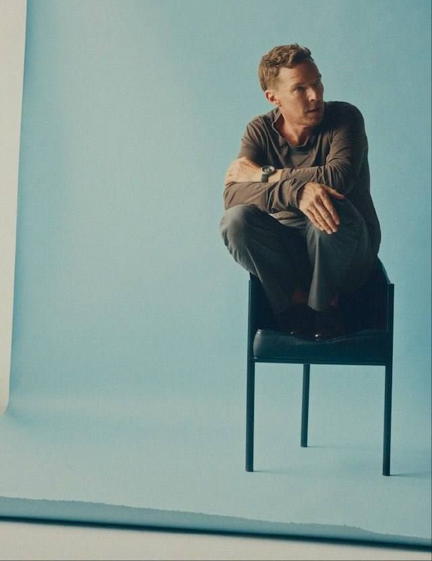 Кадр Бенедикта Камбербэтча, сидящего на стуле в студии на светлом фоне: естественная поза и минималистичная композиция.