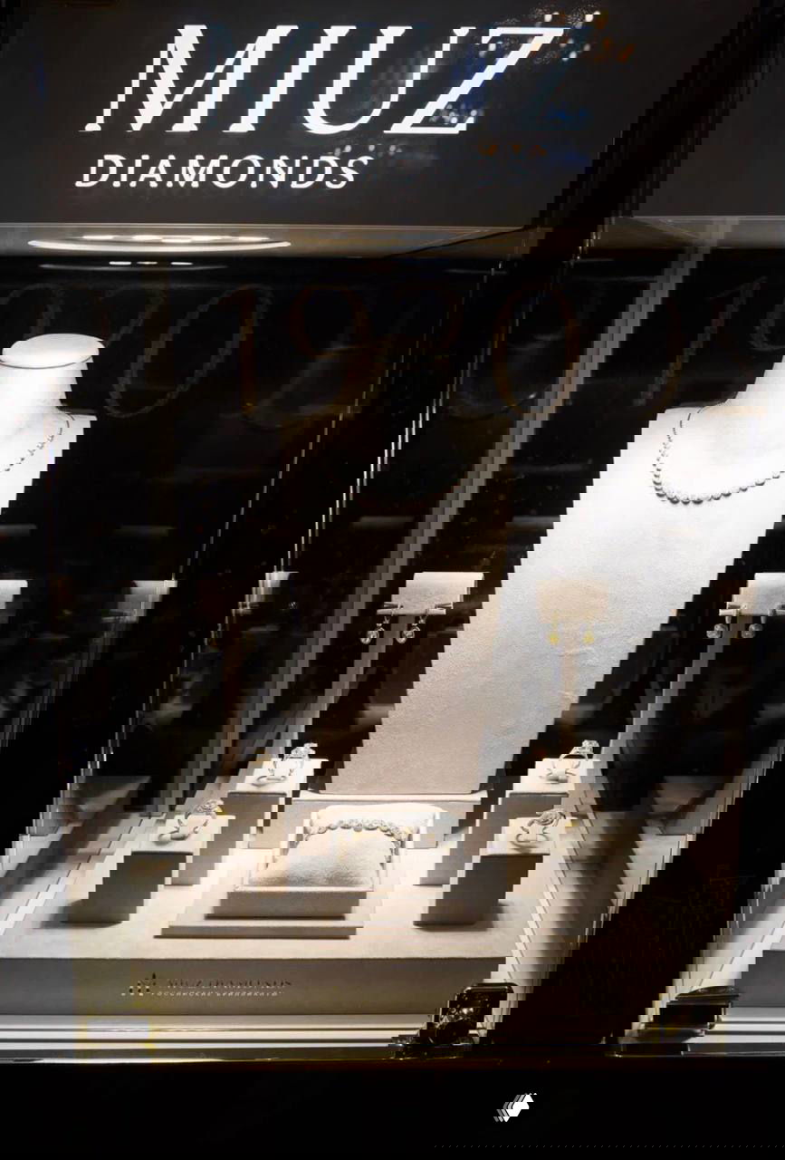 Витрина MIUZ Diamonds с жемчужным ожерельем и рядом с ним кольца и серьги — экспозиция ювелирного партнёра на церемонии награждения.