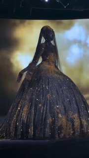 Кадр видео: пышное кутюрное платье Роберта Вуна на подиуме, ткань в золотых блёстках, драматичное освещение