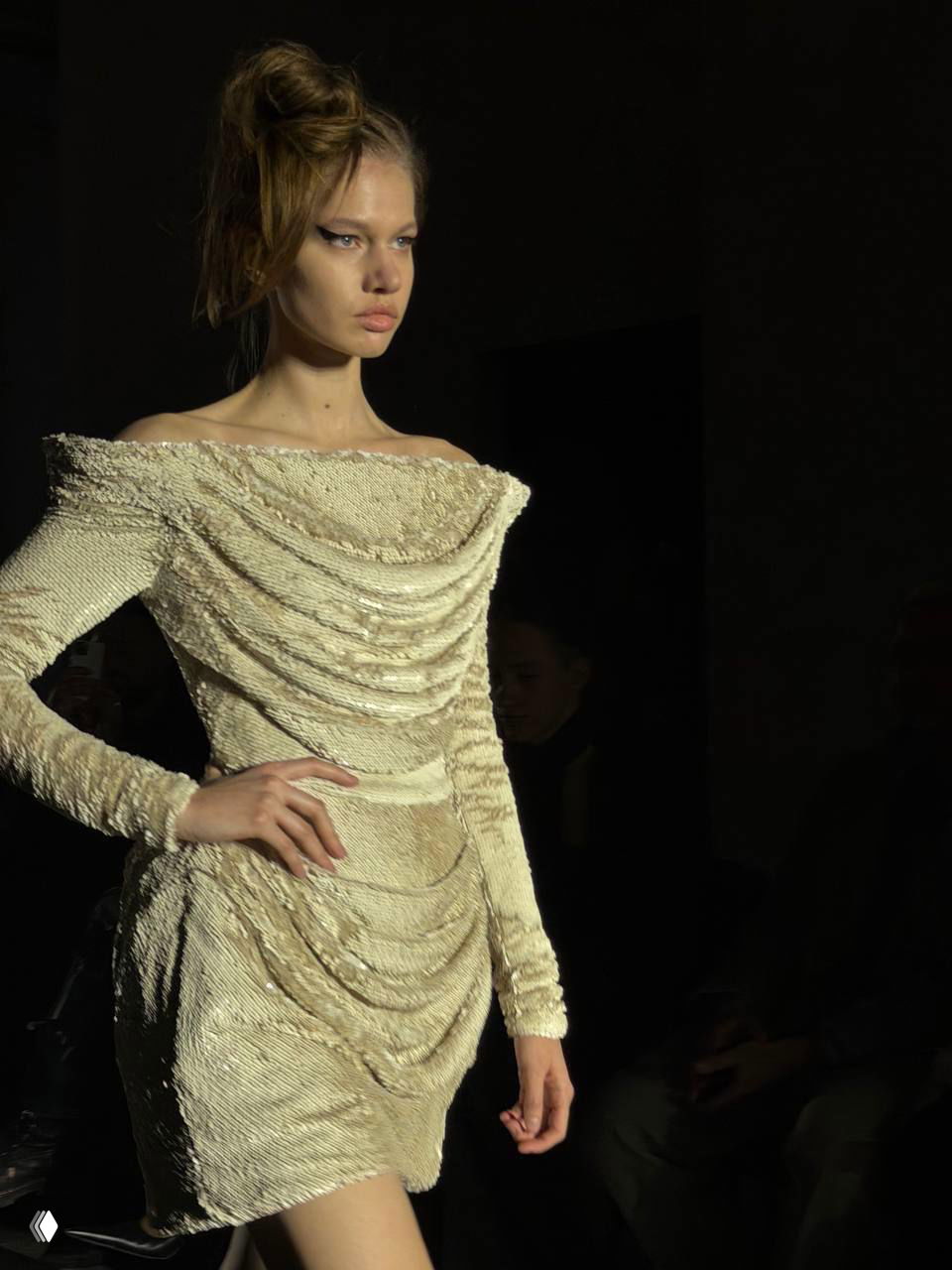 Короткое текстурированное платье кремового оттенка с драпировками и переливами ткани — деталь коллекции, снятая крупным планом.
