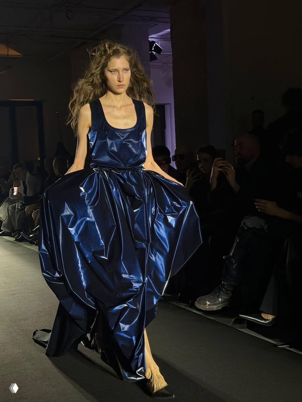Модель в темно-синем блестящем платье с пышной юбкой и растрепанными волосами — финальный образ коллекции Viva Vox на подиуме.
