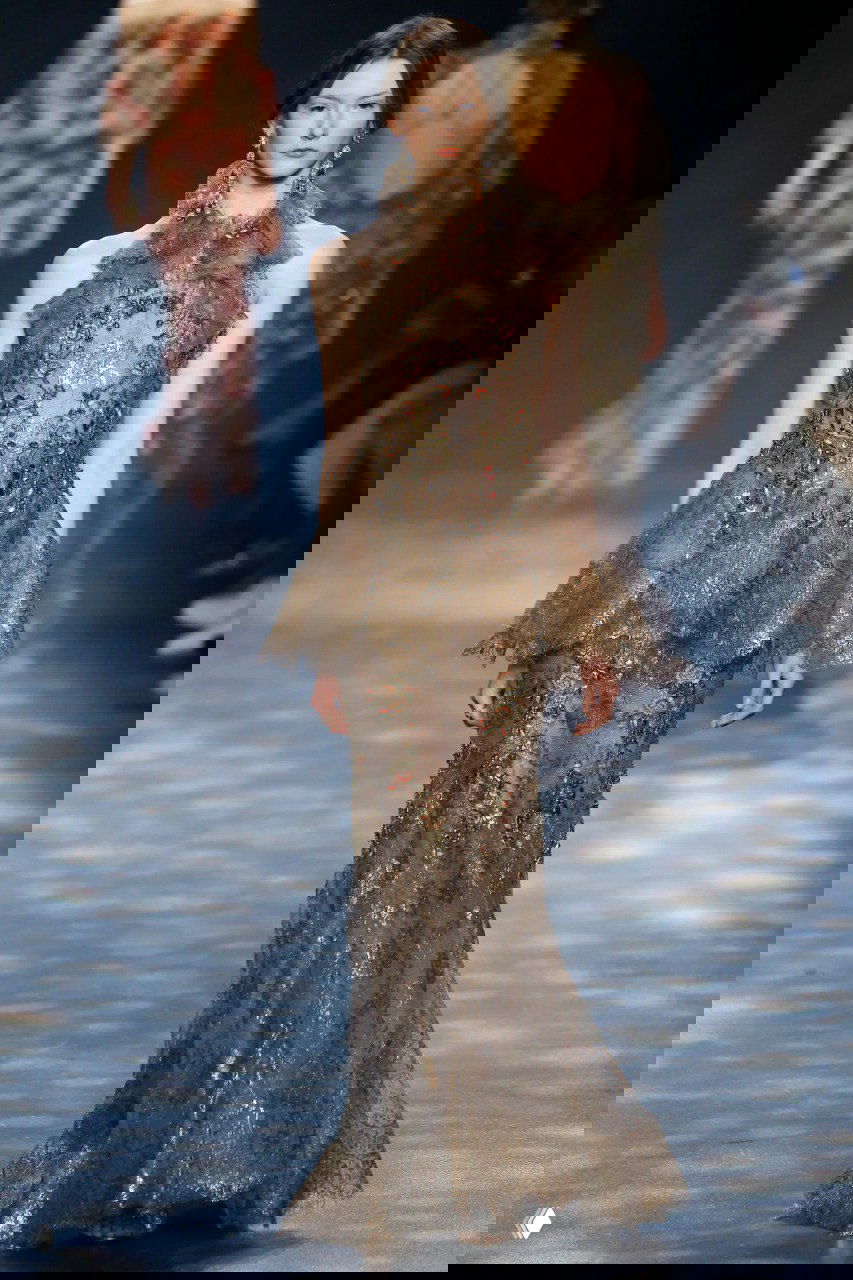 Тонкое платье с детальной вышивкой и бахромой Marchesa в светлых тонах, сочетание кружев и металликов на подиуме.