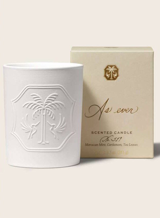 Кремовая керамическая ароматическая свеча рядом с коробкой с тиснёным логотипом и надписью; товарная фотография демонстрирует упаковку и дизайн продукта.