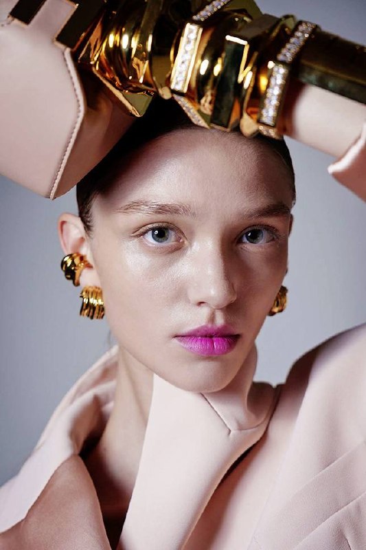 Глянцевый портрет модели с яркими губами фуксия, сияющей кожей и заметными золотыми украшениями — beauty-фото с минимальным остальным макияжем.