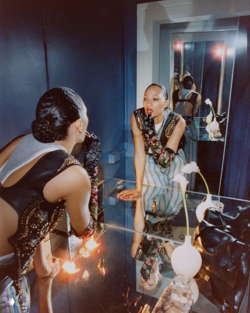 Модель у зеркала: зеркальное отражение, ванная, декоративные аксессуары и макияж в эстетике провокационного кампейна Versace.
