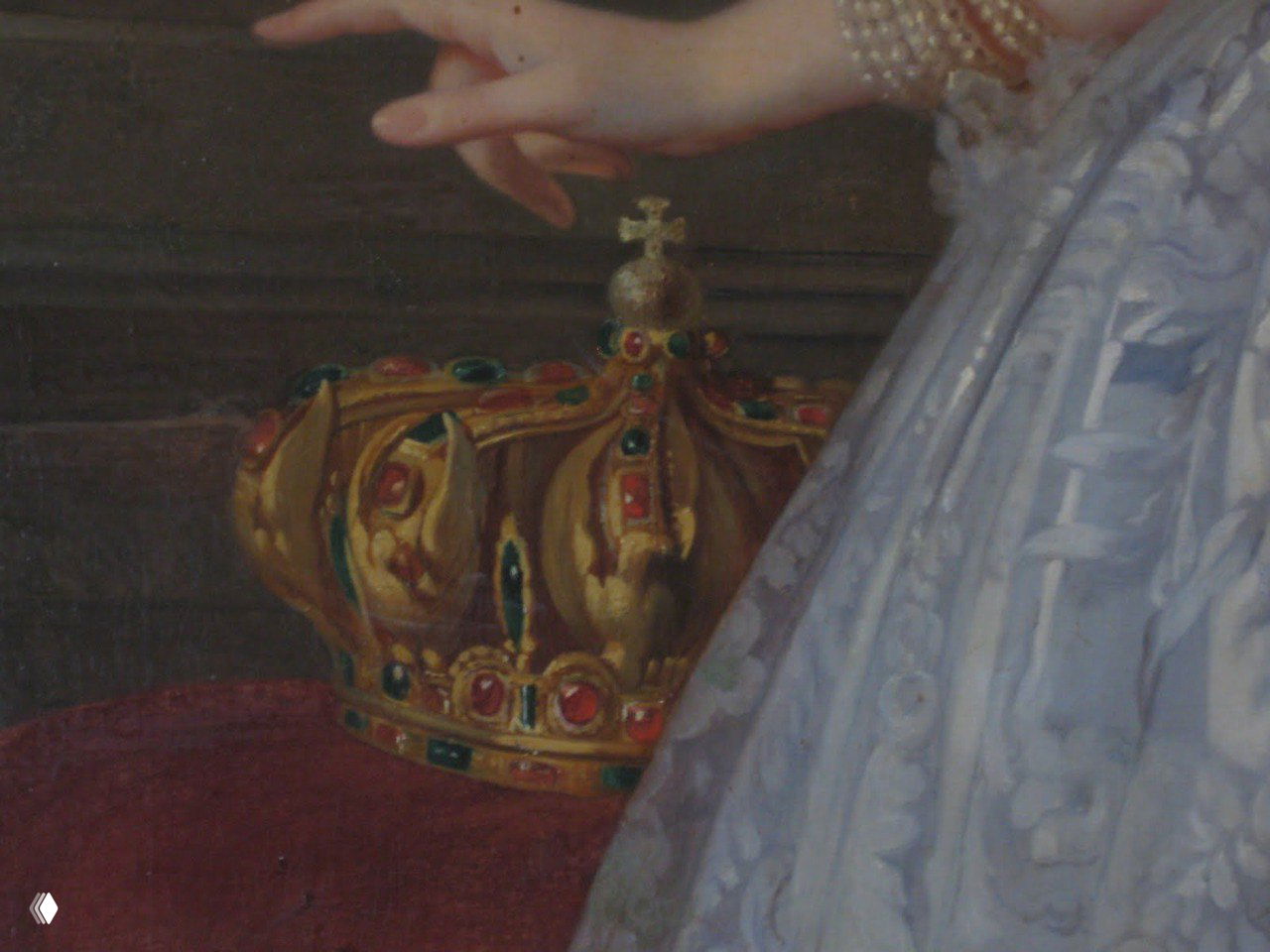 Крупный план короны с разноцветными драгоценными камнями на ткани — изображение украшения, упомянутого в материале о похищении.