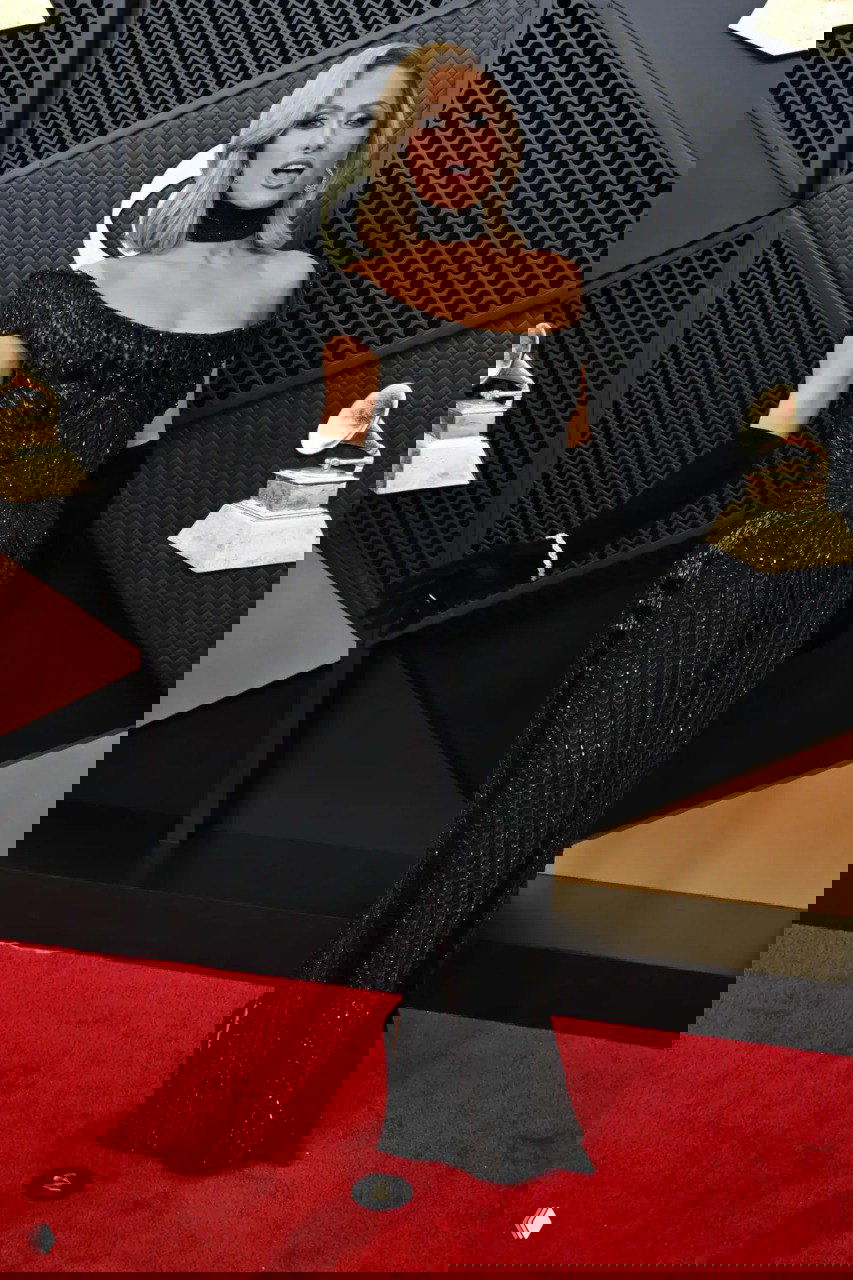 Элегантное чёрное вечернее платье в пол с открытыми плечами и длинными перчатками на красной дорожке, классический голливудский гламурный образ.