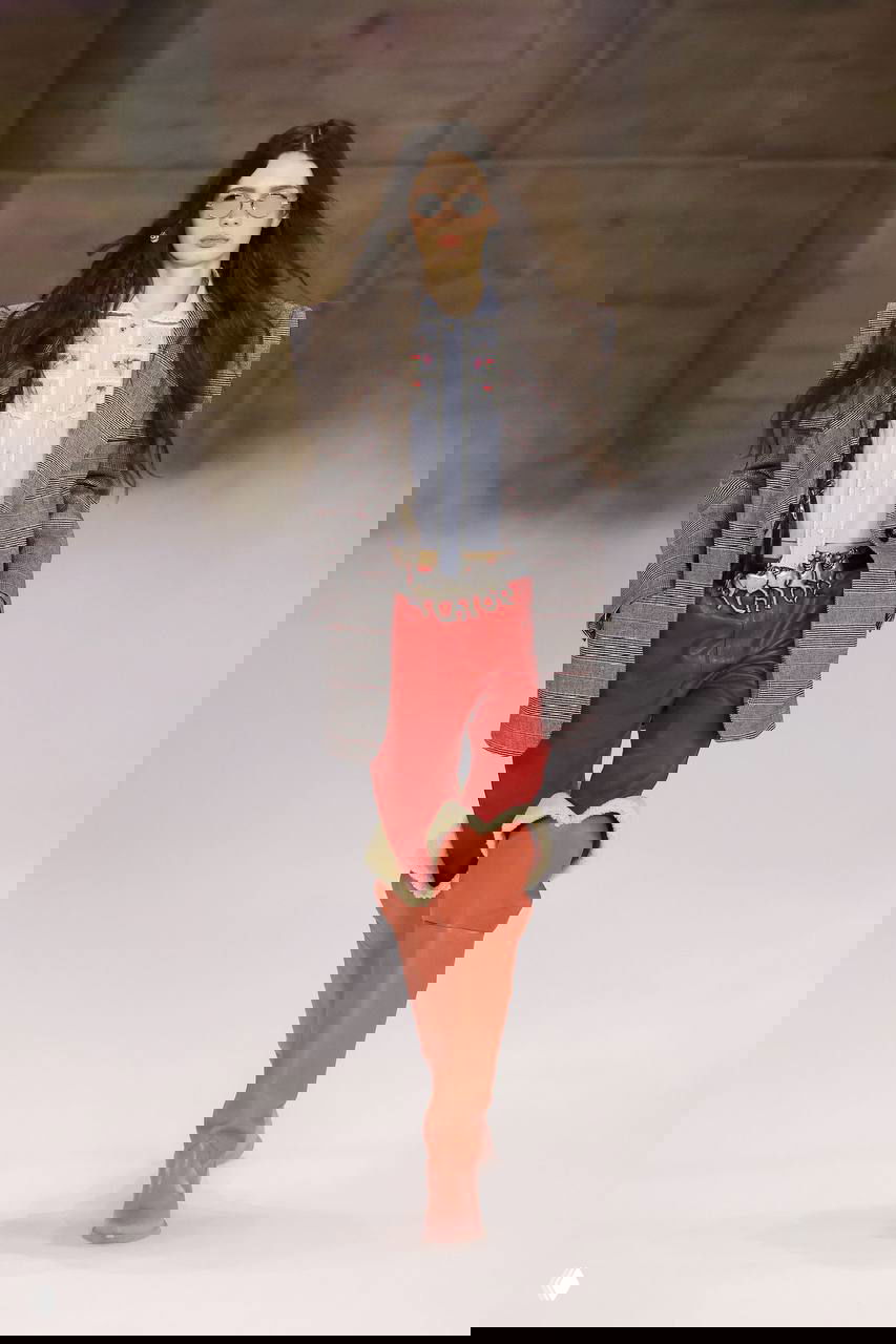 Модель в пиджаке и кожаных брюках с высокими сапогами с меховой отделкой — сочетание строгого кроя и уютных фактур в показе Chloé.