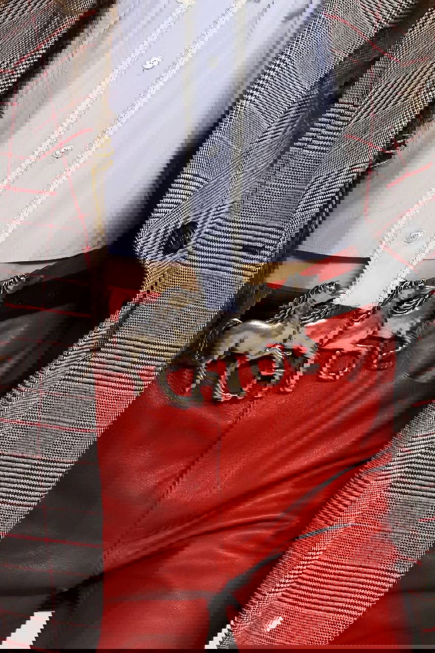 Крупный план пряжки ремня в виде фигурных лошадей и красные кожаные брюки — акцентные аксессуары и детали бренда Chloé в коллекции.