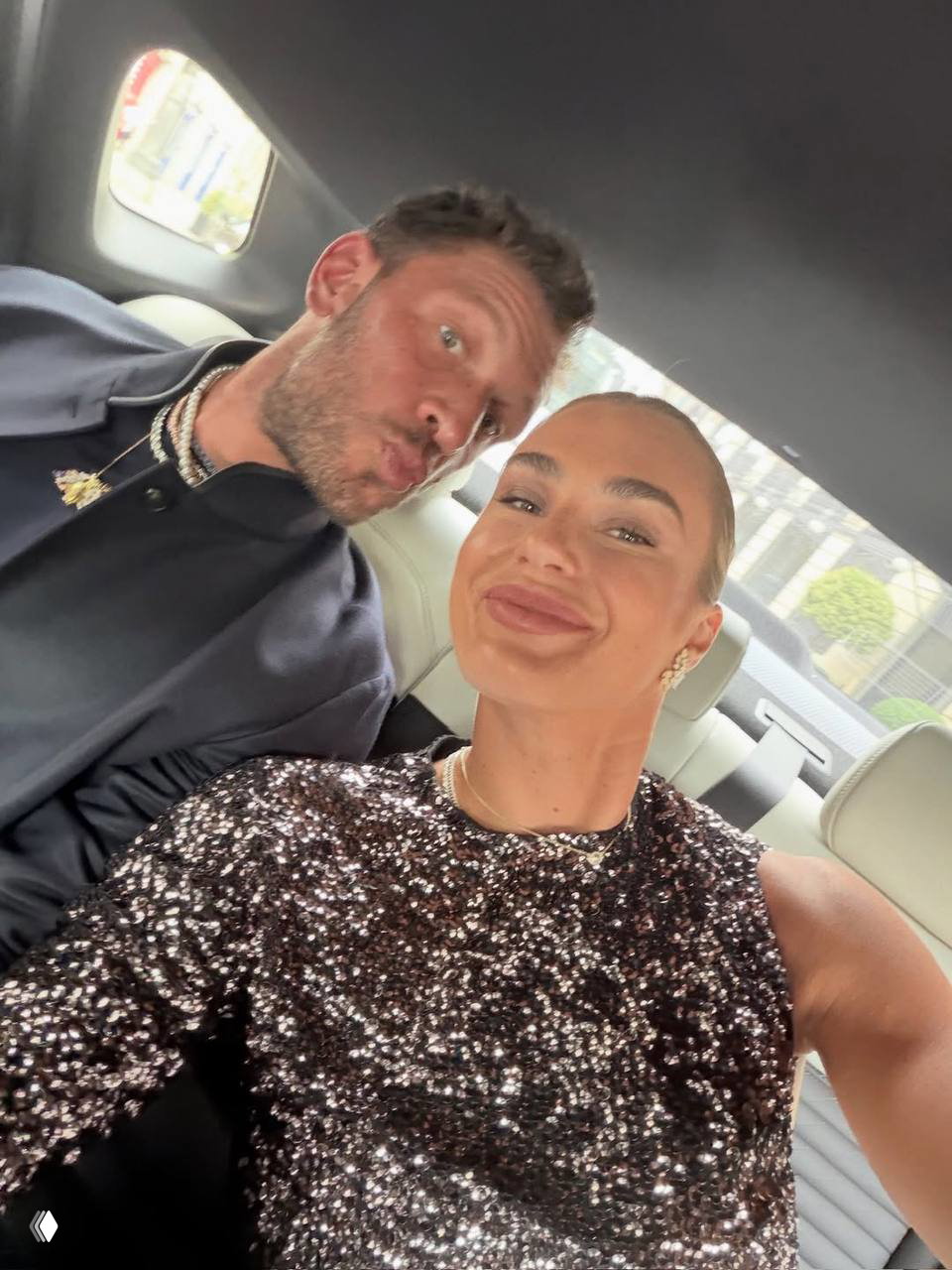 Селфи внутри автомобиля: женщина в блестящем платье и мужчина рядом с ней улыбаются в камеру после церемонии.