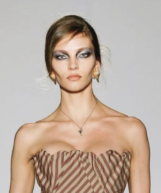 Портретная фотография модели с выразительным макияжем и серьгами — кадр с показа на Парижской неделе моды