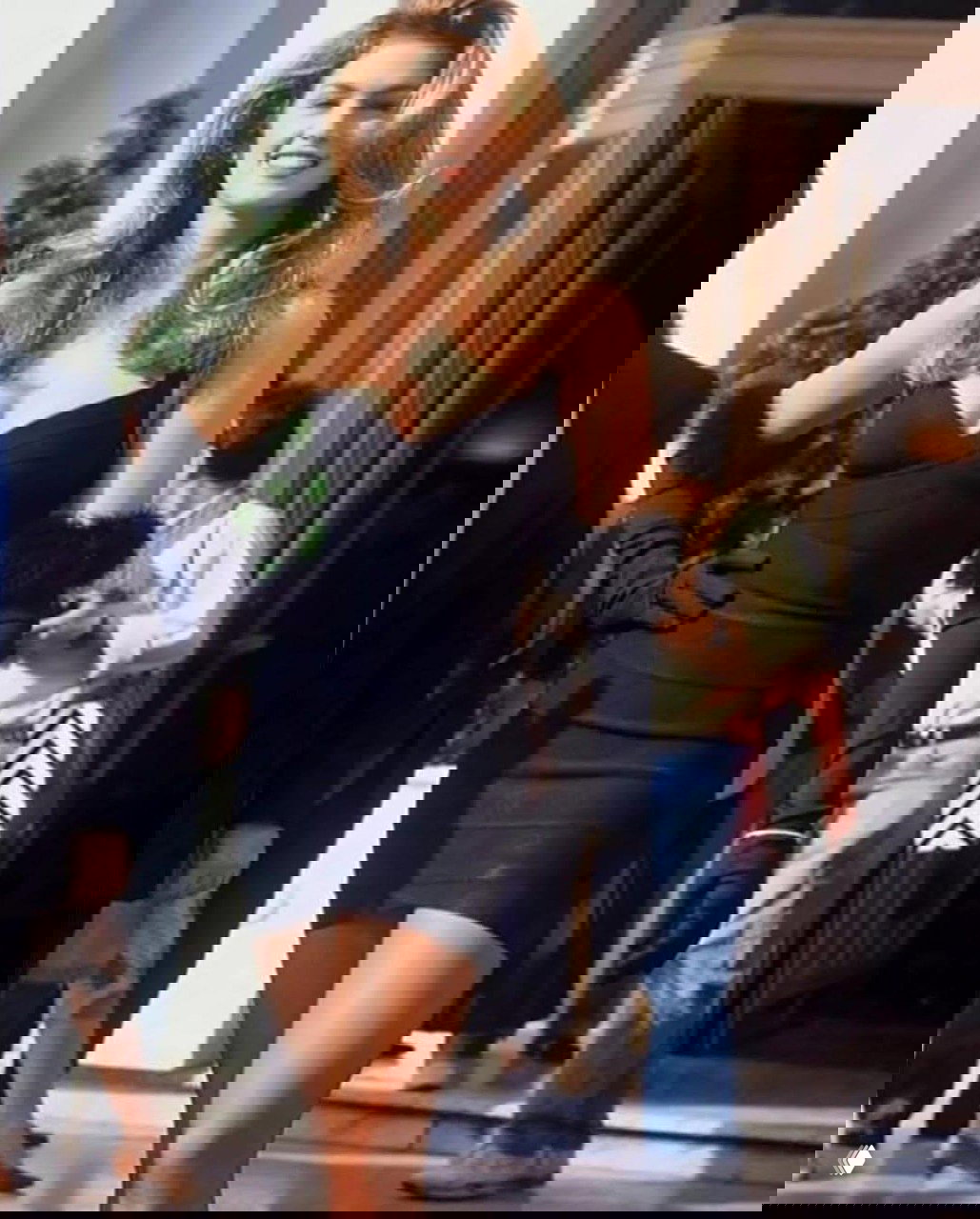 Фотография 90-х: модель в чёрном облегающем бандажном платье и длинных перчатках на улице; гламурный вечерний образ.