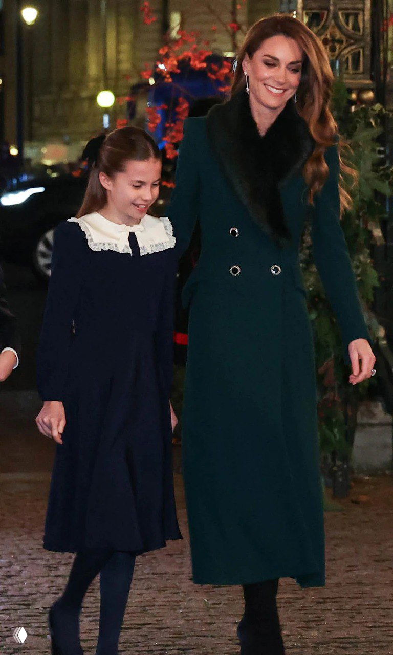 Крупный план девочки в тёмно-синем платье и взрослого в тёмном костюме, они выходят на улицу в вечернее время