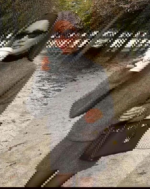 Портрет в уличном парке: образ с серой водолазкой и мини-юбкой, сумка-тоут и солнцезащитные очки создают непринуждённый стиль.