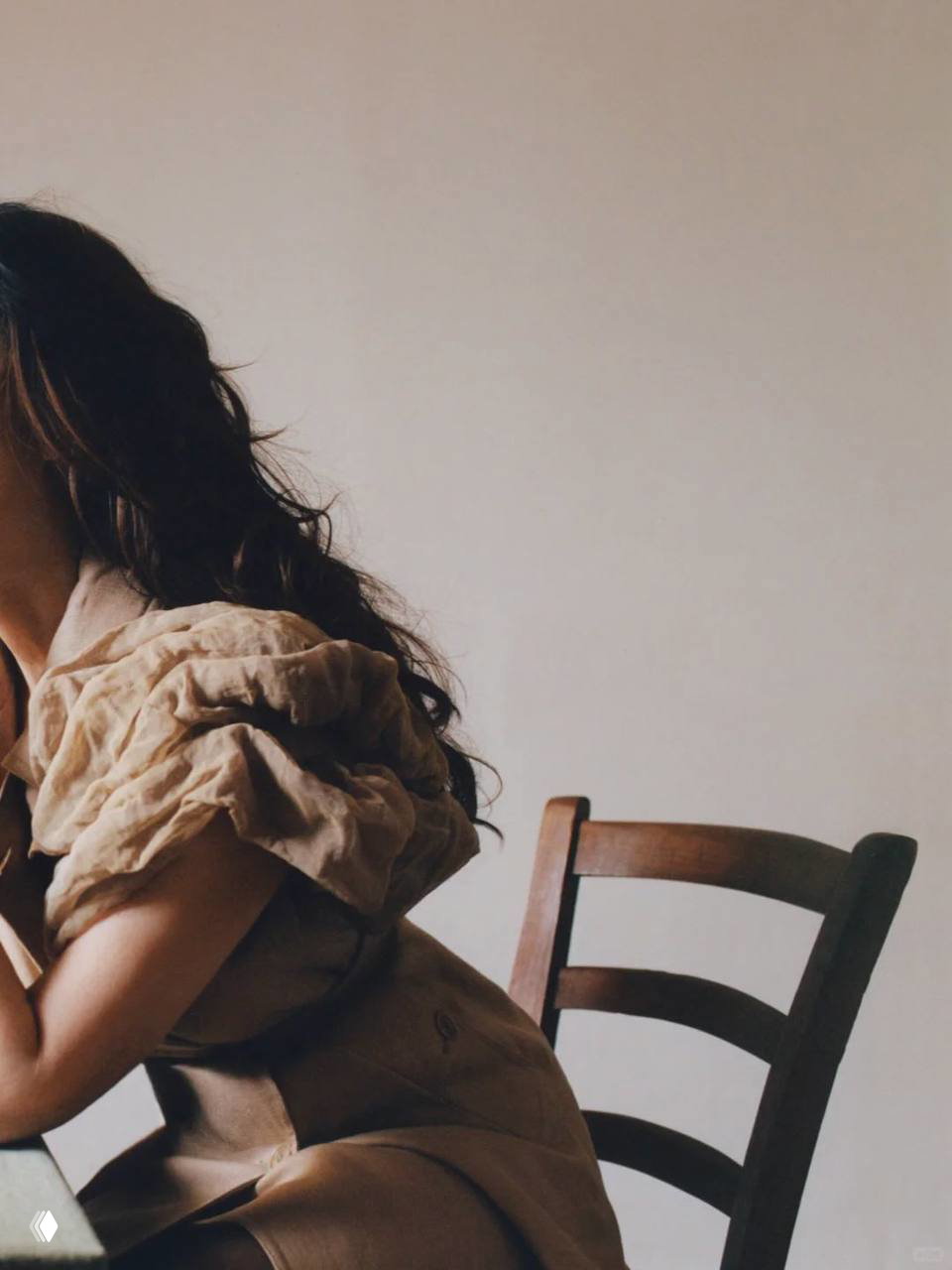 Фрагмент кадра: плечо и часть силуэта женщины в воздушном платье, минималистичный фон и спокойная гамма, акцент на текстуре ткани и силуэте.