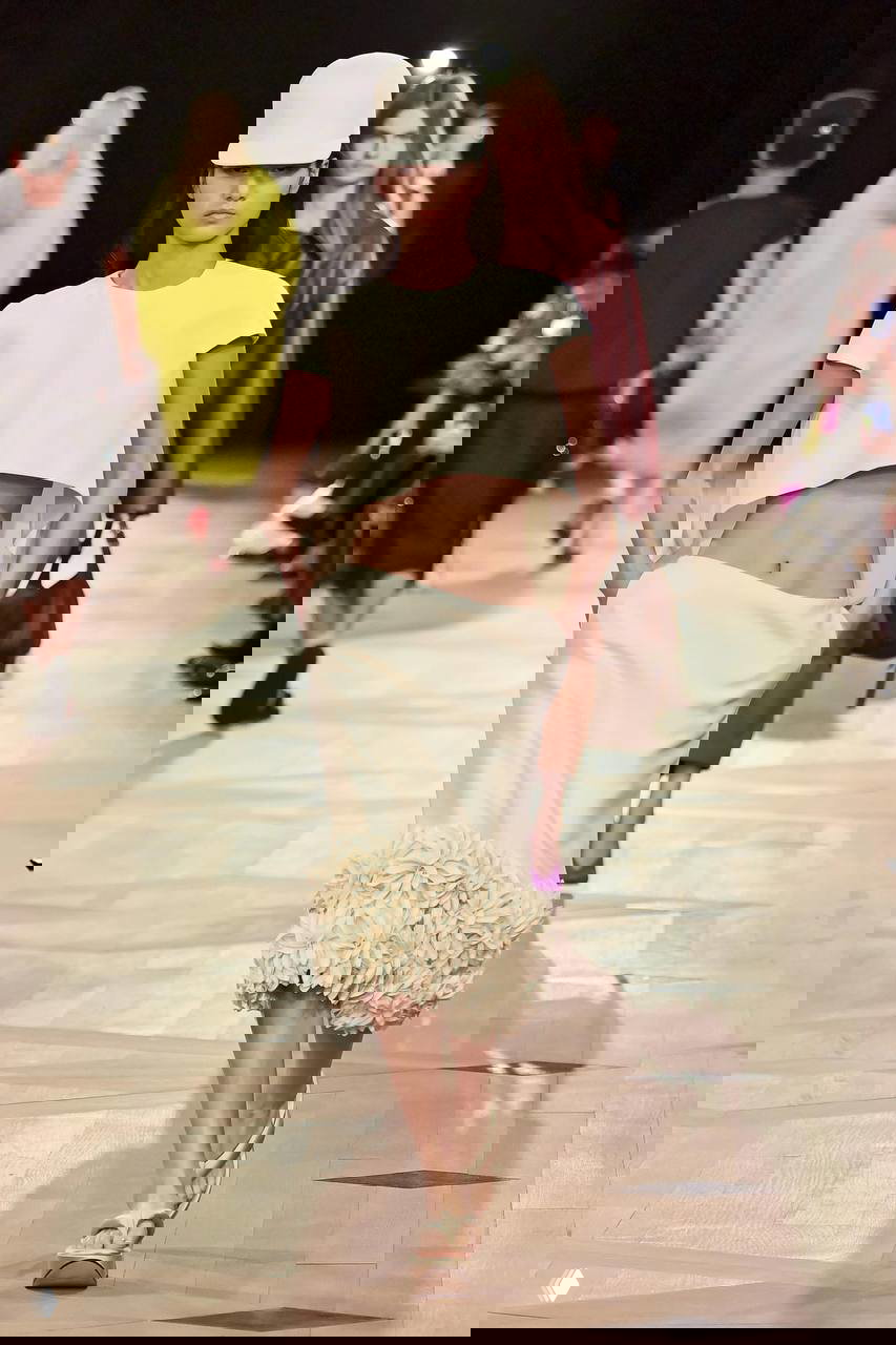 Белое платье с глубоким декольте и длинной юбкой на подиуме, сочетание классической простоты и современных силуэтов в коллекциях 2026.