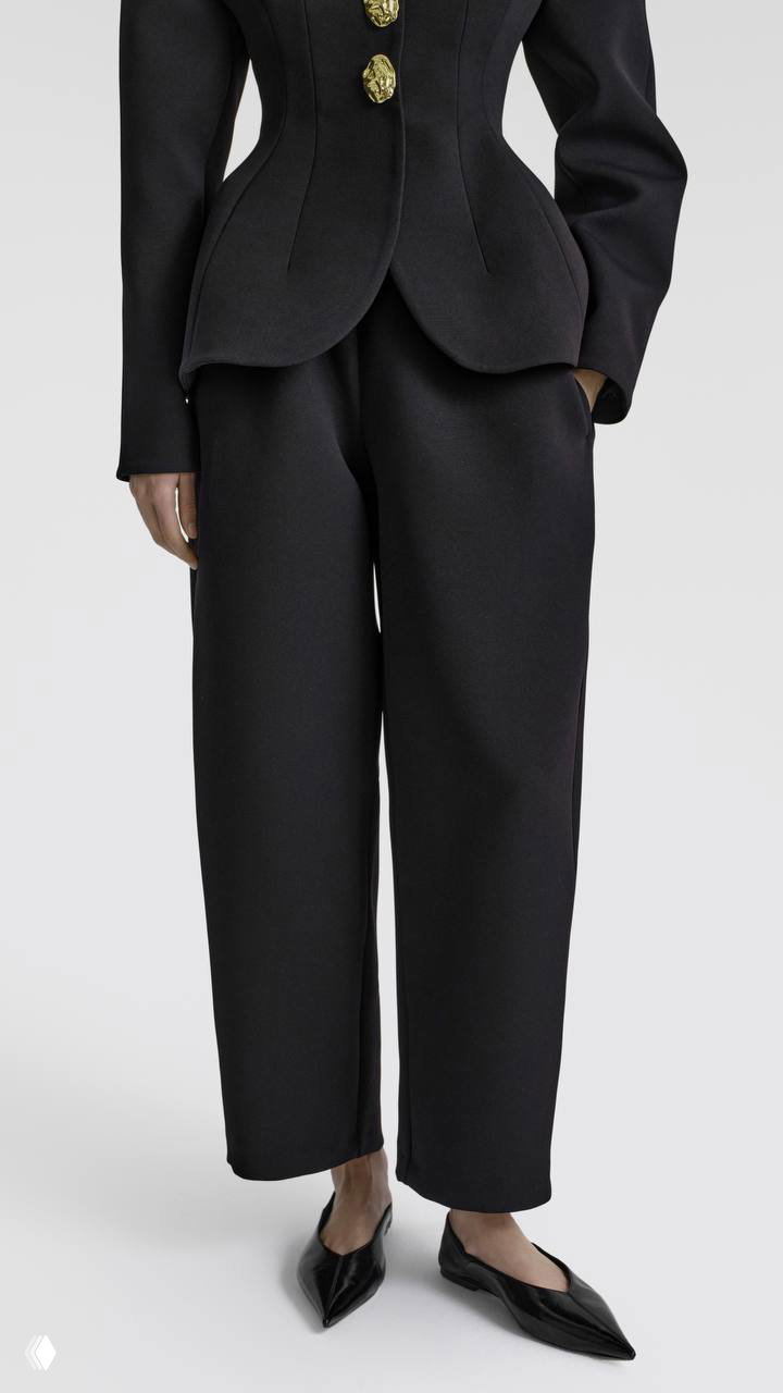 Нижняя часть черного костюма: приталенный жакет с золотыми пуговицами и свободные строгие брюки, акцент на силуэте и обуви‑балетках.