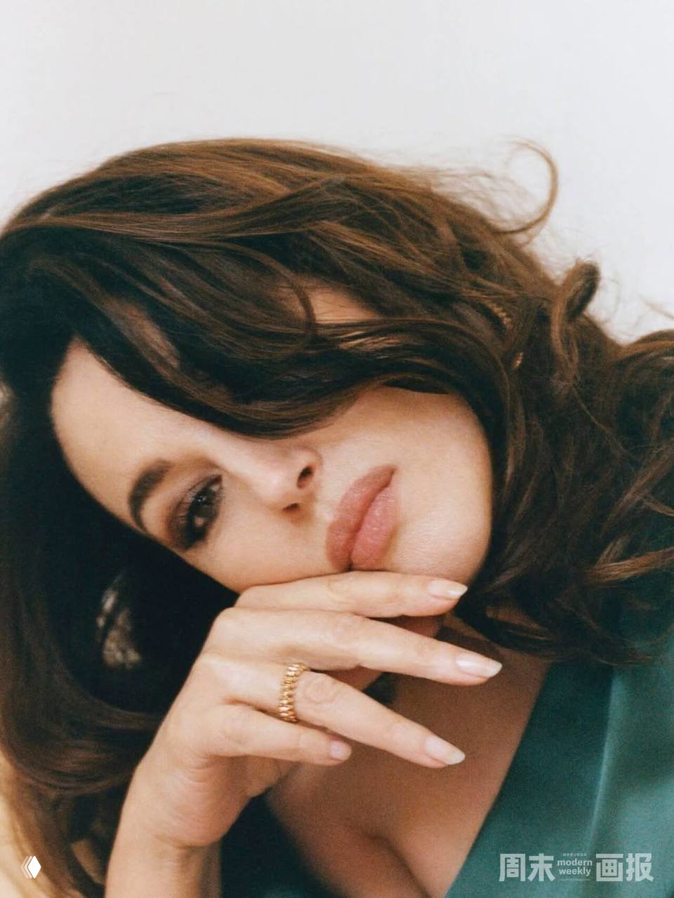 Макро-портрет: лицо и взгляд женщины в крупном плане, естественный макияж и рука у подбородка, мягкая съёмка с акцентом на эмоции и детали.