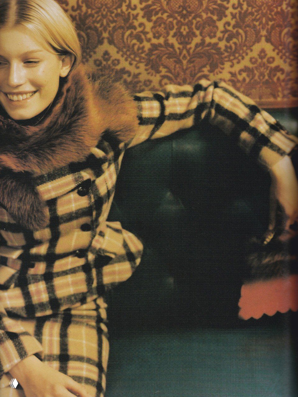 Никки Мохуд улыбается в клетчатом пальто с меховой отделкой, осенняя стилистика и интерьерная текстура на снимке 1998 года.