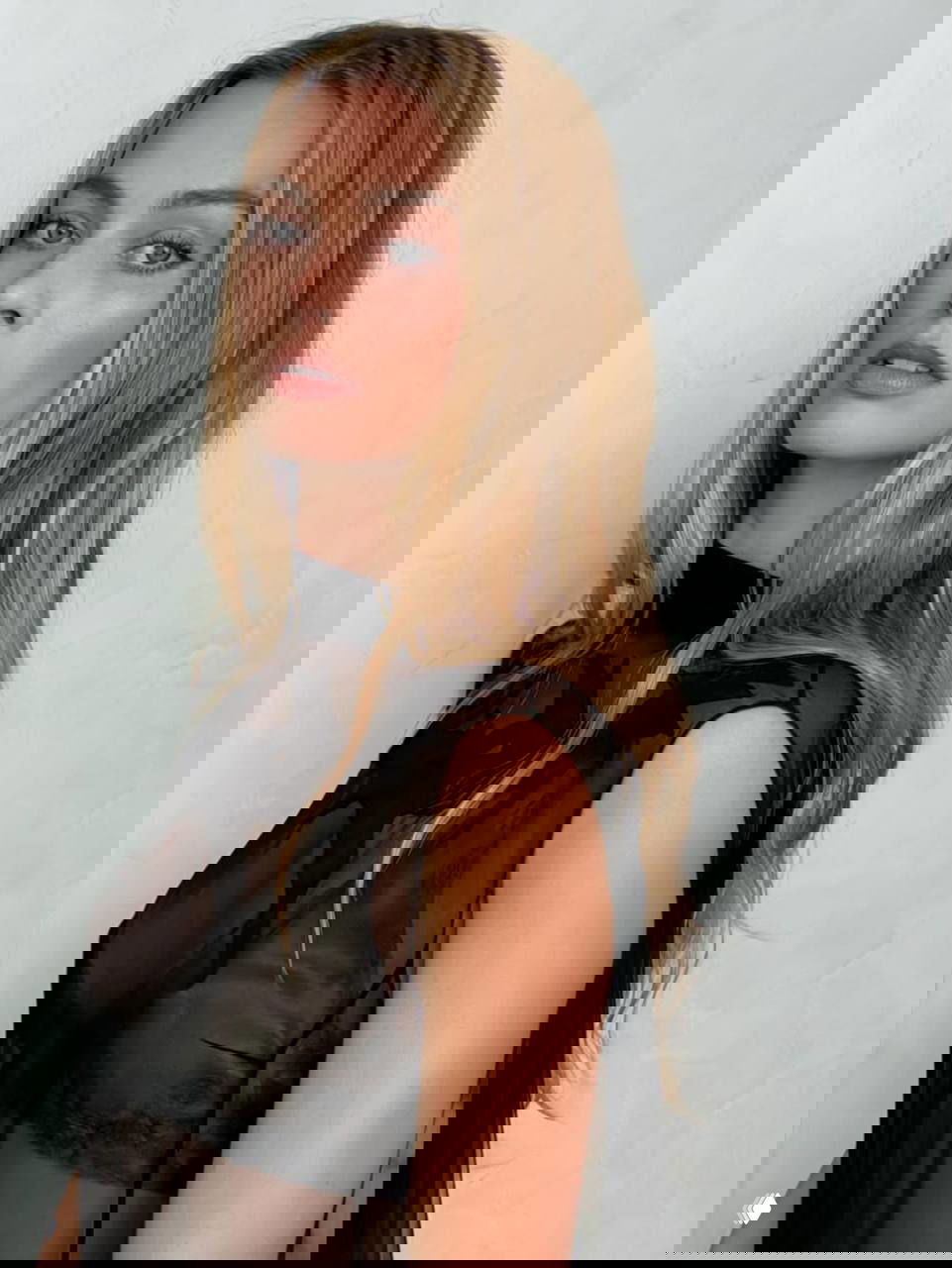 Крупный план женщины в полупрозрачном верхе и аккуратной прическе; фокус на макияже, текстурах ткани и выразительном взгляде в студийной обстановке.