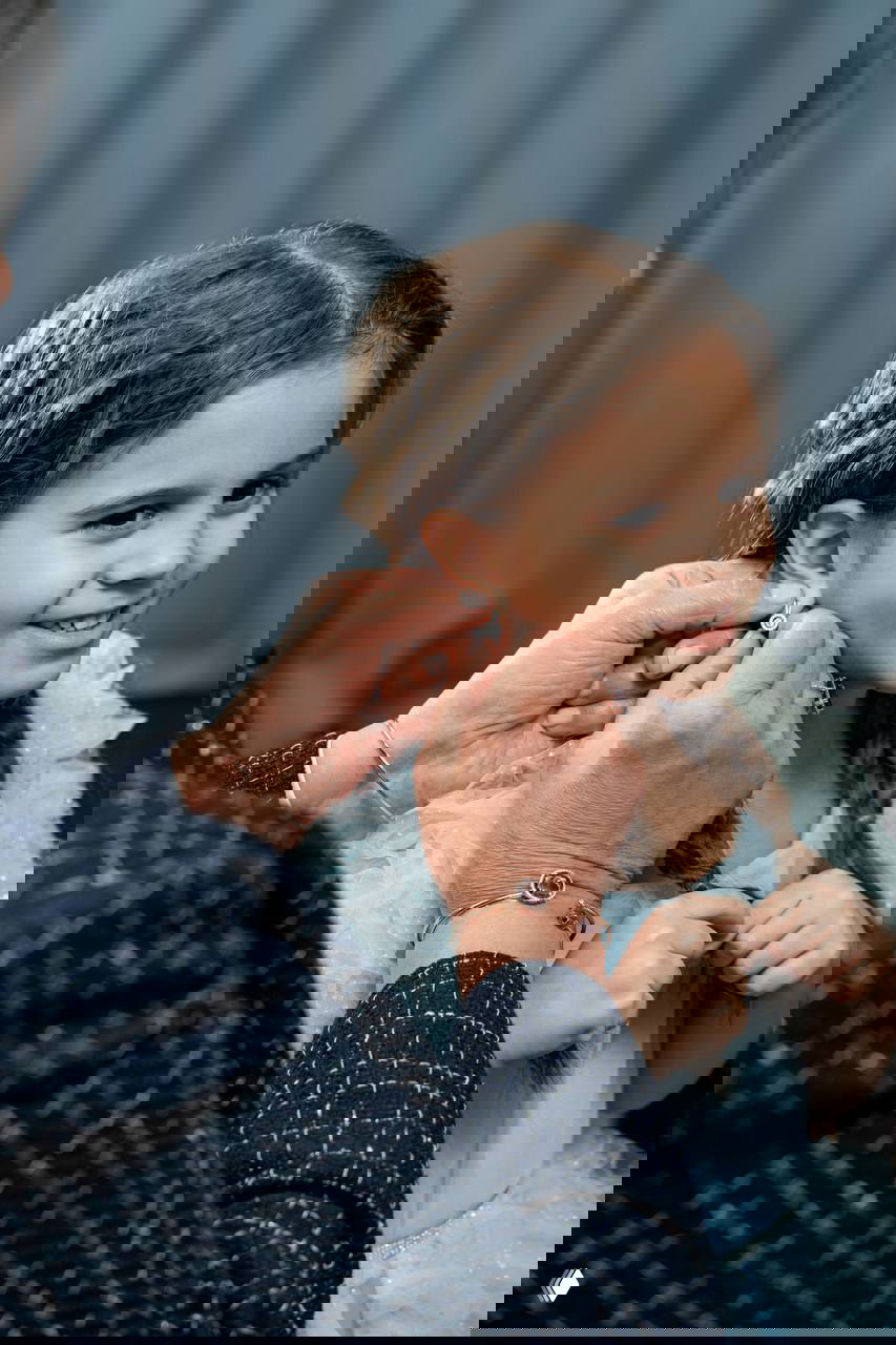 Татьяна Овечкина надевает серьгу на девочку — кадр, передающий тёплую семейную сцену и связь поколений в ролике бренда.