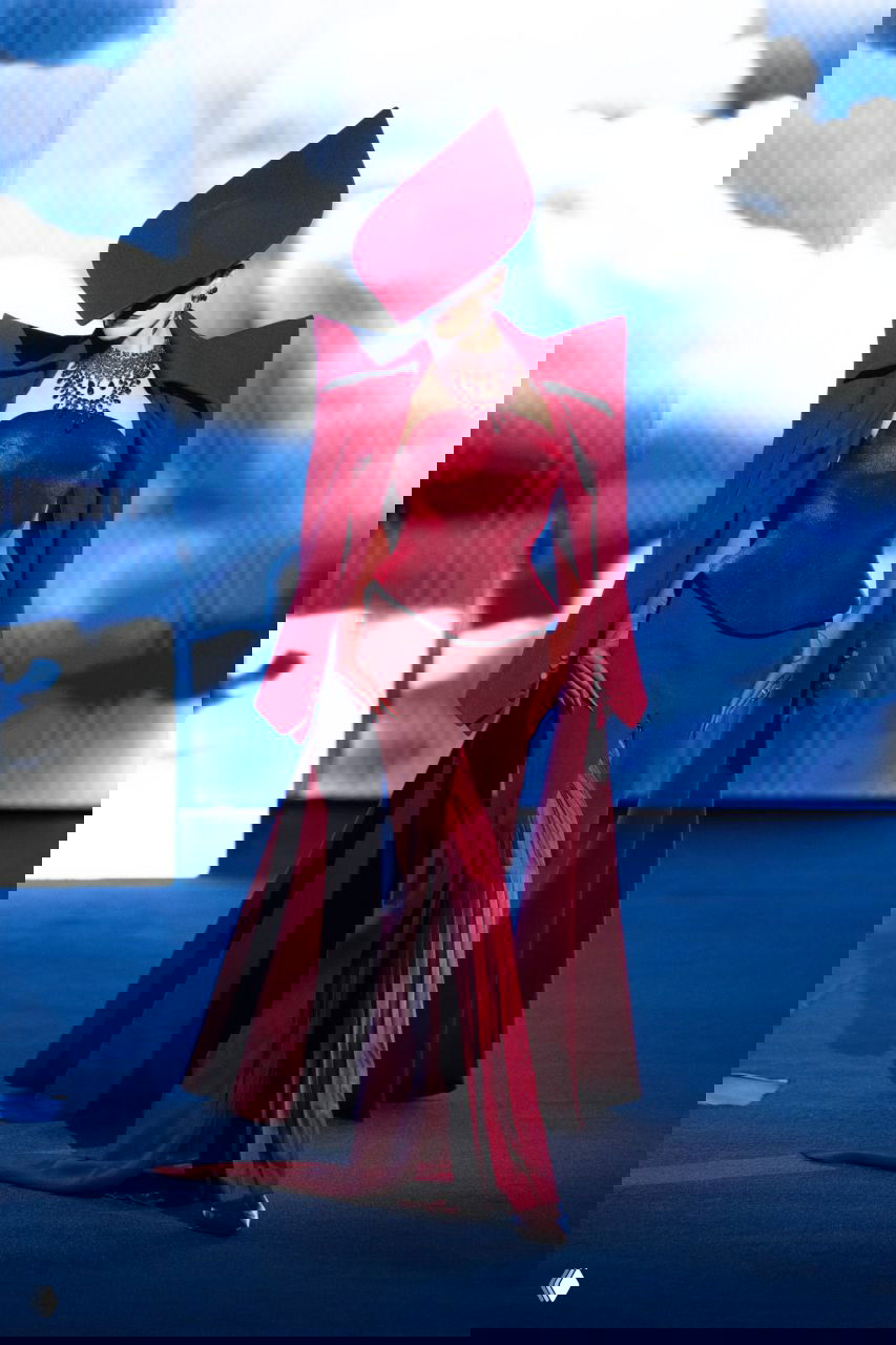 Бордовый ансамбль с корсетом и крупным головным аксессуаром: драматичная комбинация плотных тканей и тонких драпировок в кутюре Роберта Вуна.