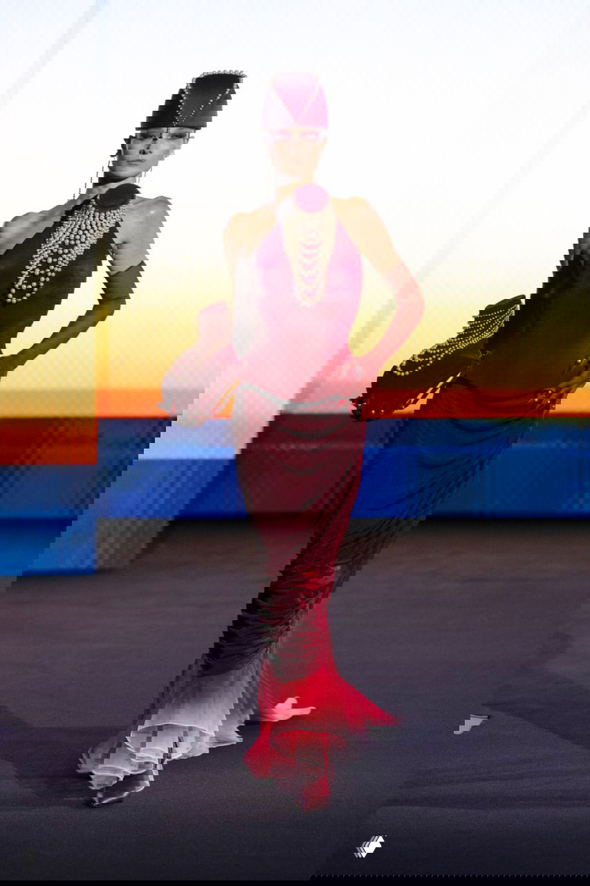 Тонкое платье с жемчужной отделкой и высокими аксессуарами: образ в оттенках бордо и перламутра на фоне заката — часть показа Роберта Вуна.