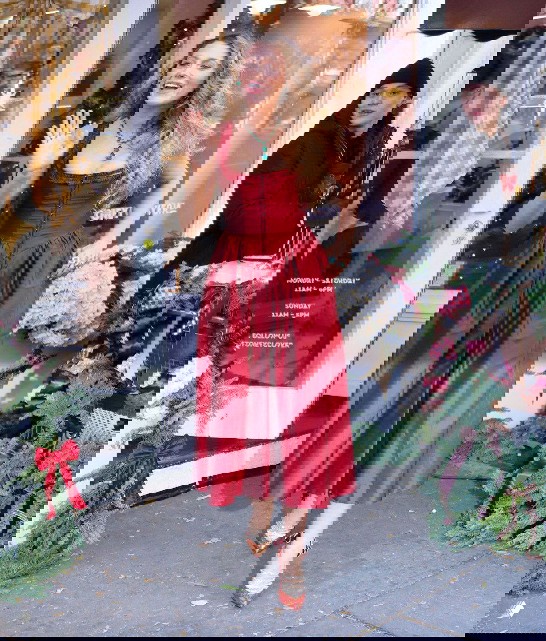 Полнотелый кадр Блейк Лайвли в бордовом миди‑платье Annina Alice на открытии Stoney Clover Lane в Нью‑Йорке среди рождественских декораций.