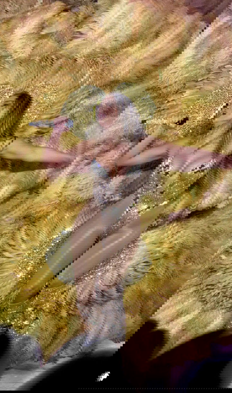 Дженнифер Лопес в сценическом костюме и крупными перьями во время выступления — кадр с мини-концерта, который она дала на свадебном приёме.