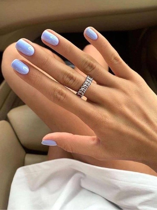 Рука в светлой рубашке с нежно-голубым маникюром, вид сверху на пол и обувь; тон ногтей гармонирует с одеждой и аксессуарами.