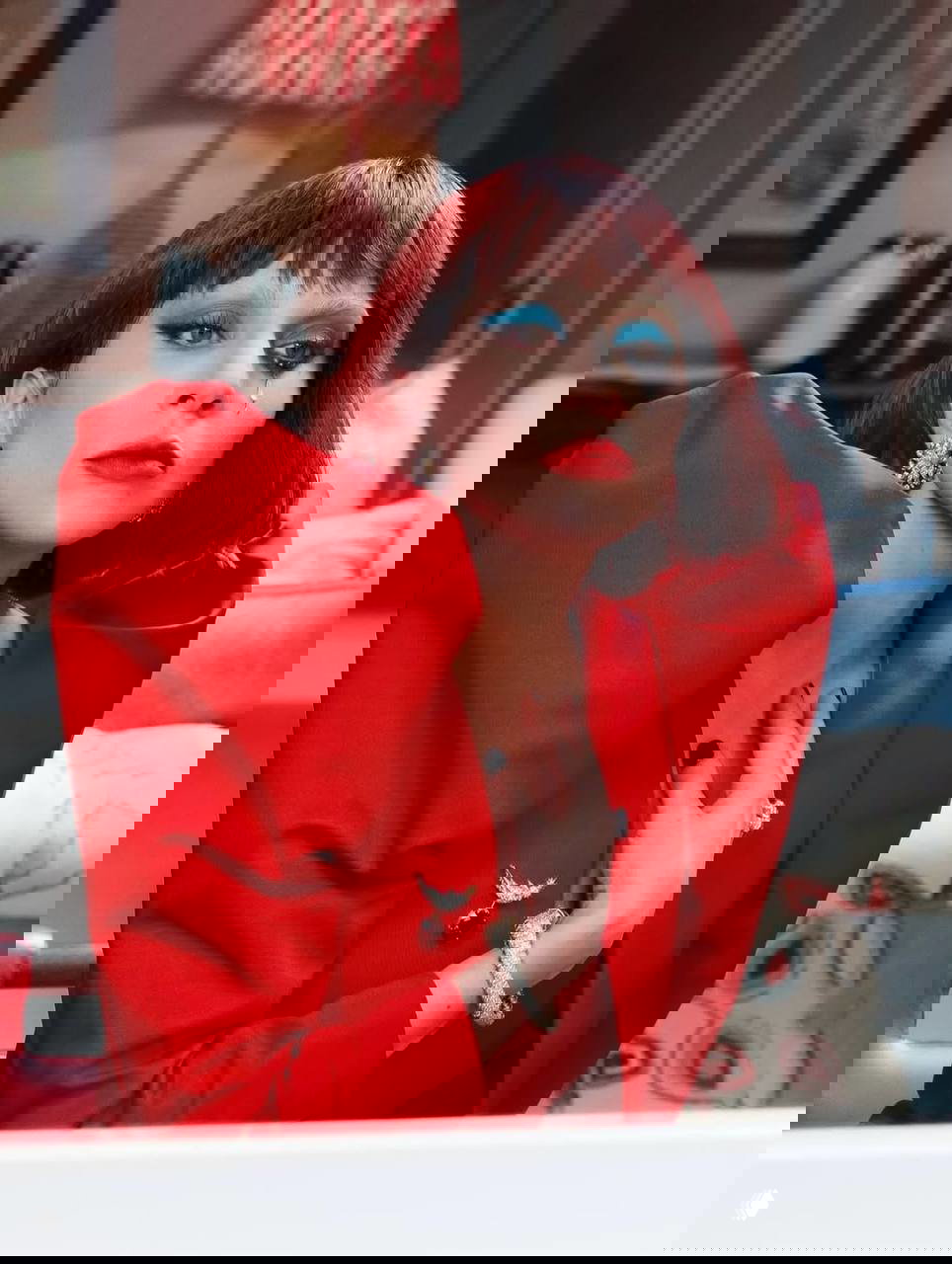 Цветной портрет: женщина с короткой тёмно‑рыжей причёской, ярким голубым макияжем глаз и насыщенной красной помадой, интерьер на заднем плане.