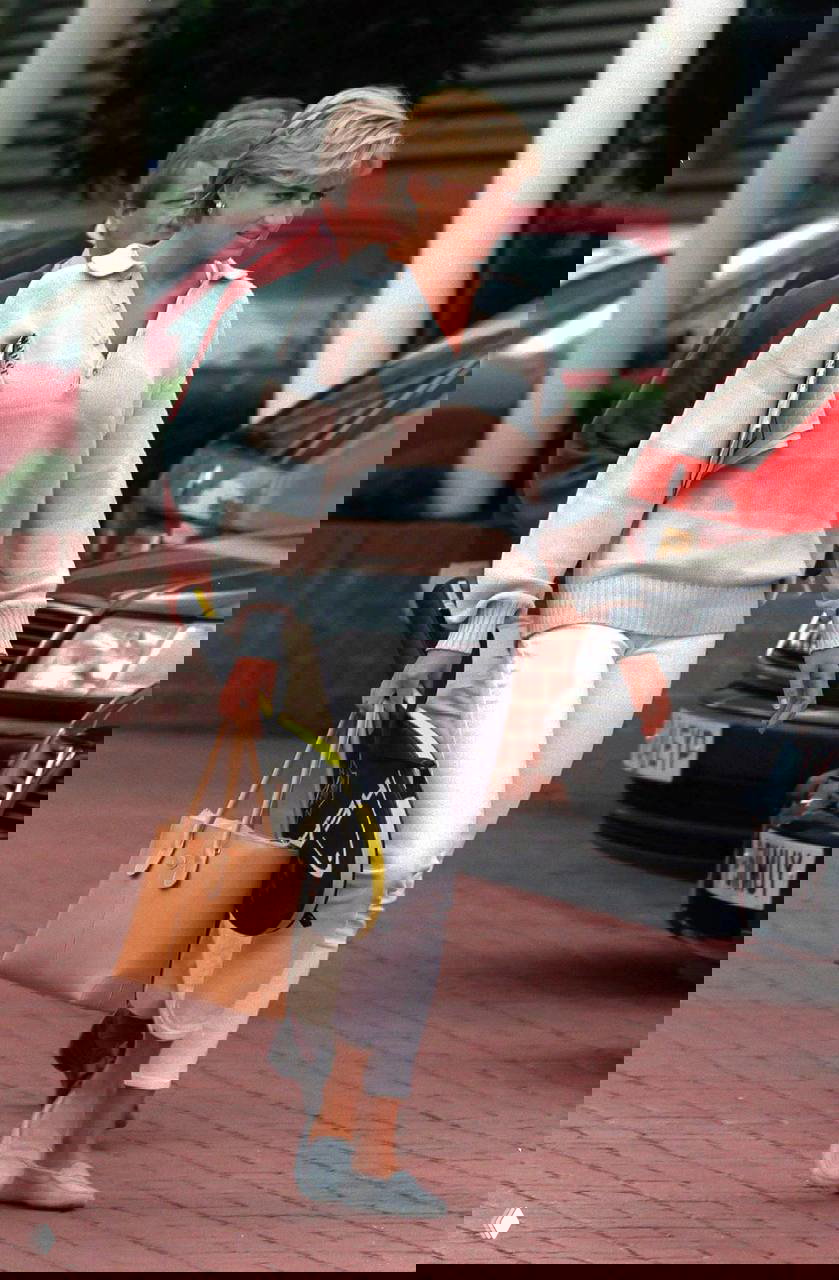 Фотография в мягких пастельных тонах: полосатый джемпер, белые брюки и сумка, спортивно-элегантный повседневный лук.