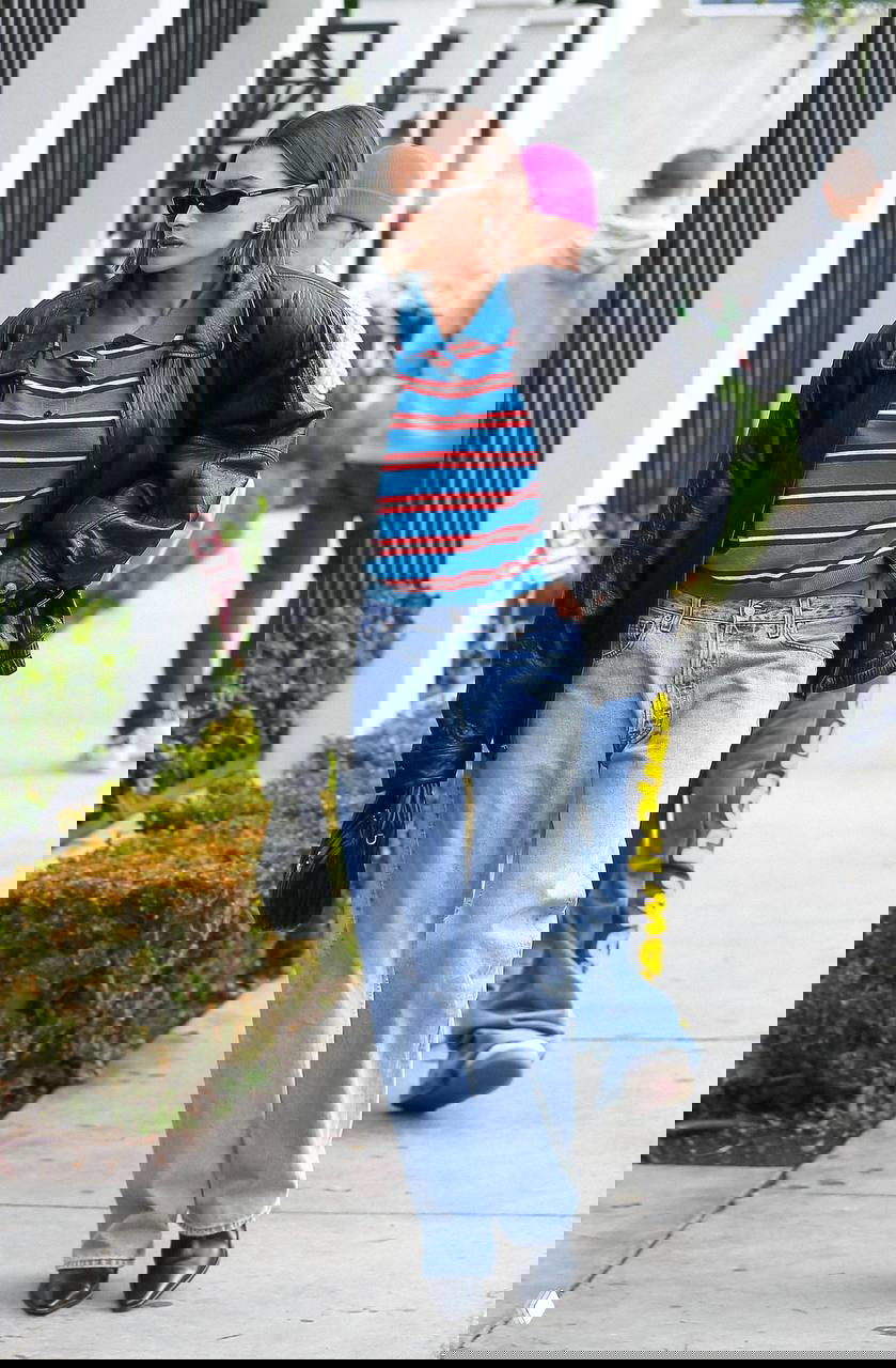 Уличный образ с оверсайз-кожаной курткой, полосатым регби-поло и прямыми джинсами, городской расслабленный стиль в деталях.