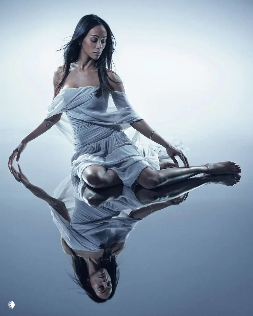 Женщина сидит на поверхности с отражением в воде, воздушное платье и плавные позы создают образ мечтательной бьюти‑фотосессии.