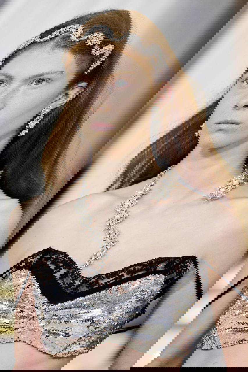 Портрет молодая модель с тонким ободком и асимметричным ожерельем‑лепестком: сочетание деликатного декора и королевской тематики в украшениях.