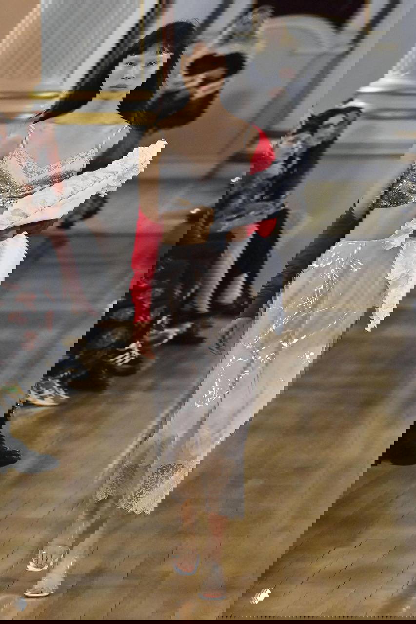 Показ с пижамным топом и кружевным платьем, на модели также заметен мужской оверсайз-пиджак — сочетание интимности и улицы.