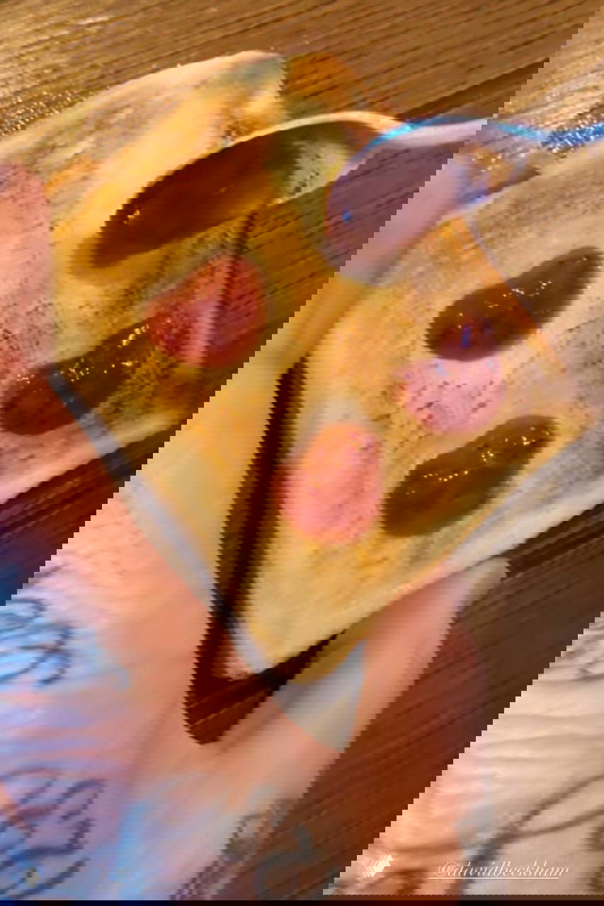 Поджаренный тост с джемом, выложенным в форме маленьких сердечек; видно руку с татуировками и ложку с джемом — романтический завтрак.