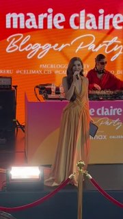 Выступление артистки на сцене Marie Claire Blogger Party: певица перед микрофоном и сцена с подсветкой и ограждением для гостей.