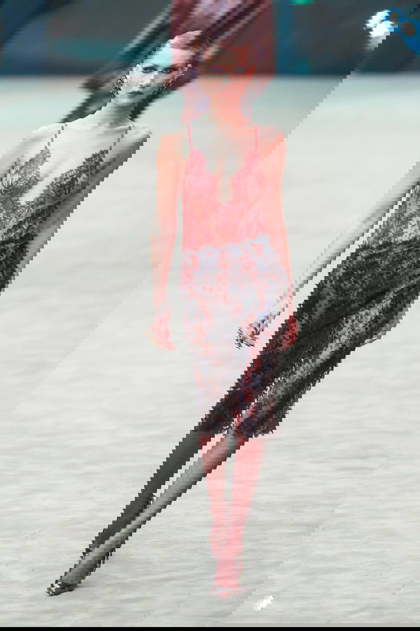 Прозрачное кружевное платье на подиуме: тонкая работа с текстурами и прозрачностью в паре с элементами корсета, иллюстрация глэм‑ретро влияний.