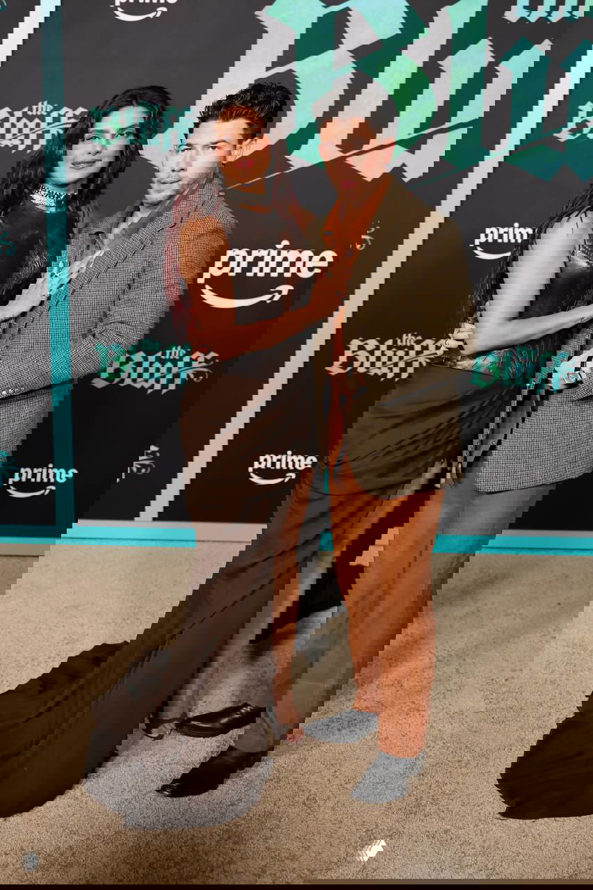 Пара позирует вместе: Приянка в элегантном корсете и длинной юбке с разрезом, Ник в коричневых брюках и твидовом пиджаке на премьере.