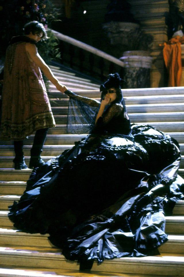 Готический сценический образ: модель в объёмном чёрном платье с длинным шлейфом и вуалью, атмосфера театра и драмы в коллекции Dior 1998.