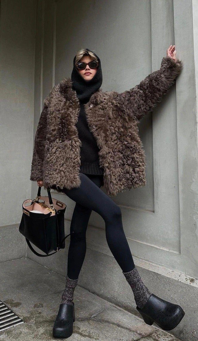 Девушка в кудрявой шубе из овчины коричневого оттенка, сочетание с тёмными лосинами и платформенной обувью, стильный городской лук