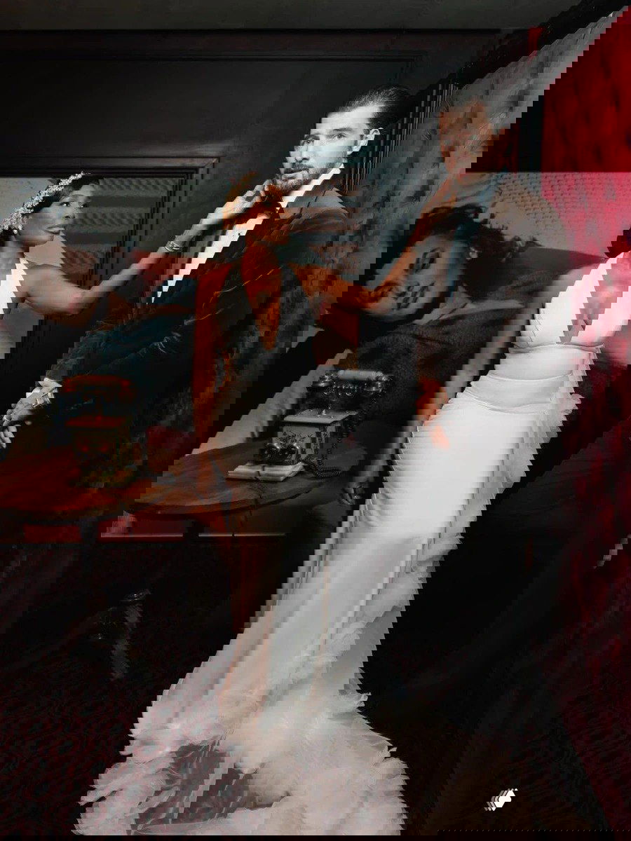 Невеста и жених позируют в тёплой интерьерной зоне: Винус в изящном платье, жених в классическом смокинге — вечерний лук для приёма.