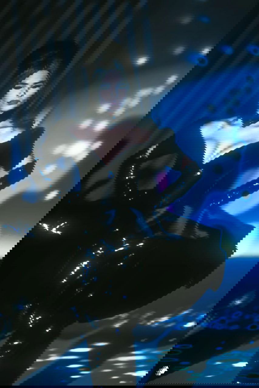 Драматичный образ в чёрном облегающем платье и длинных перчатках — стильная сцена с контрастным освещением на показе Mugler 1990.