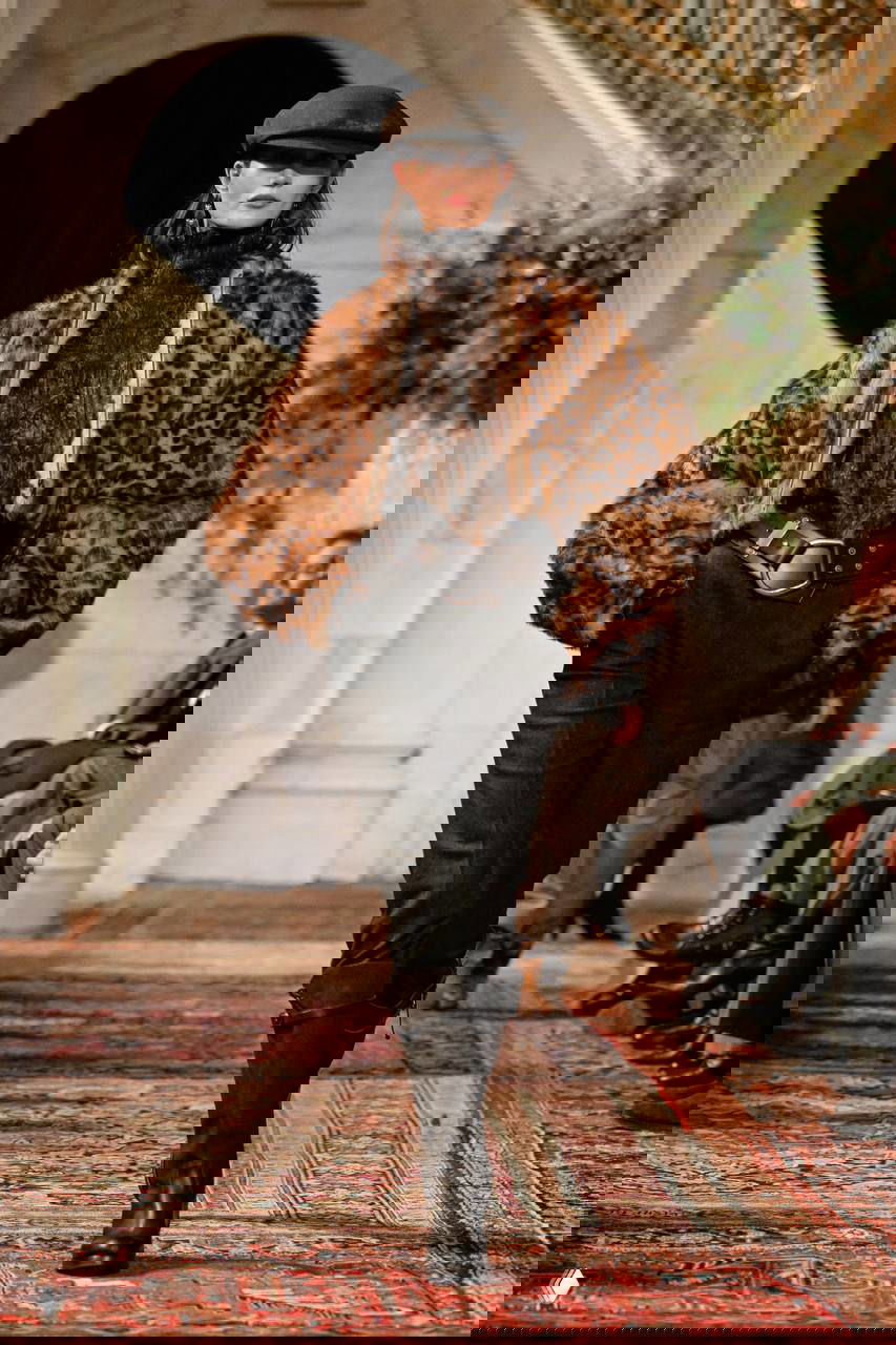 Модель в леопардовой шубе, кепи и широком ремне с крупными пряжками, высокие сапоги и ковер подиума подчёркивают сафари-нотки в коллекции.