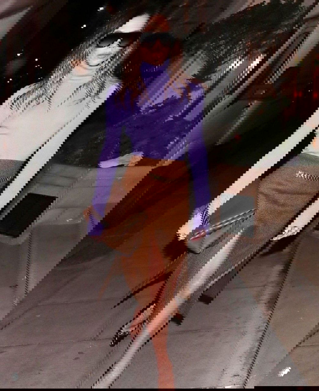 Ночной городской образ: светло-сиреневая водолазка в сочетании с коричневой юбкой и клатчем — фиолетовый как мягкий акцент вечернего лука.