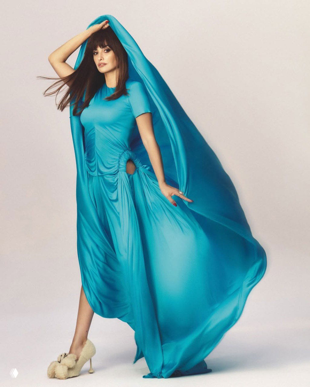 Женщина в ярком бирюзовом струящемся платье: развевающаяся ткань, динамичная поза и элегантная обувь на нейтральном студийном фоне